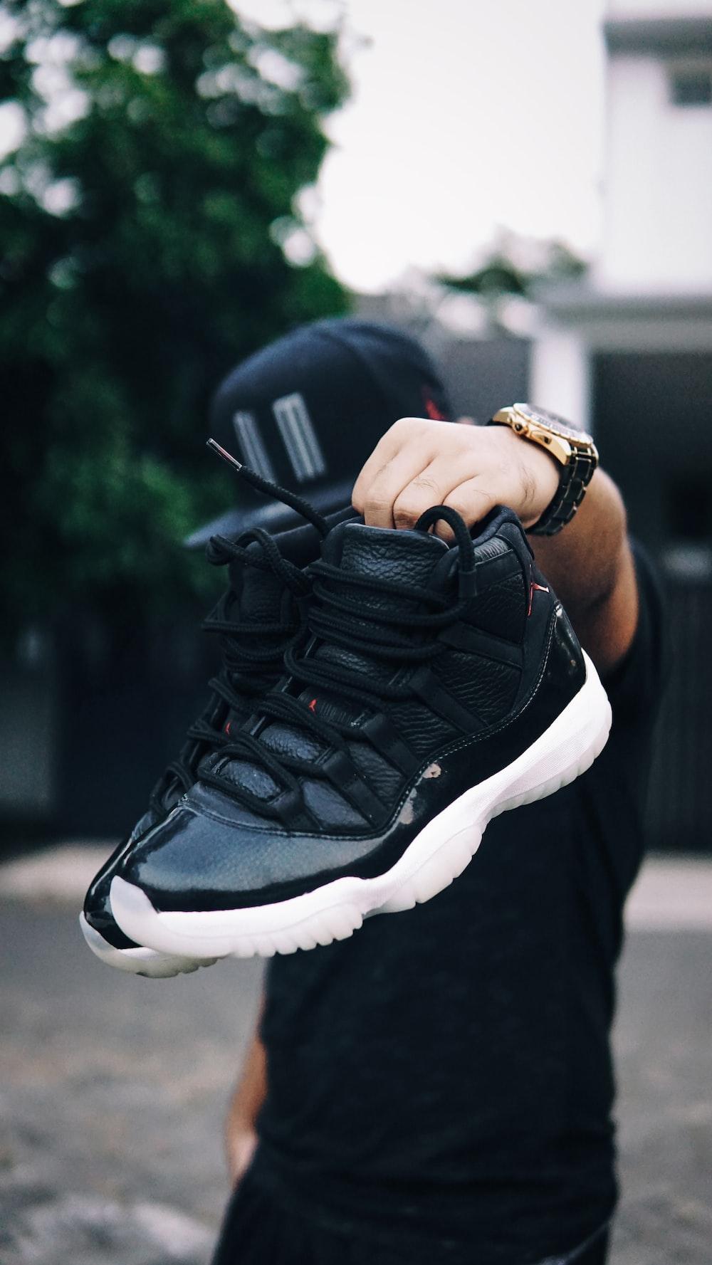 1000x1777 Person Holding Pair Of Black And White Air Jordan 11's Photo