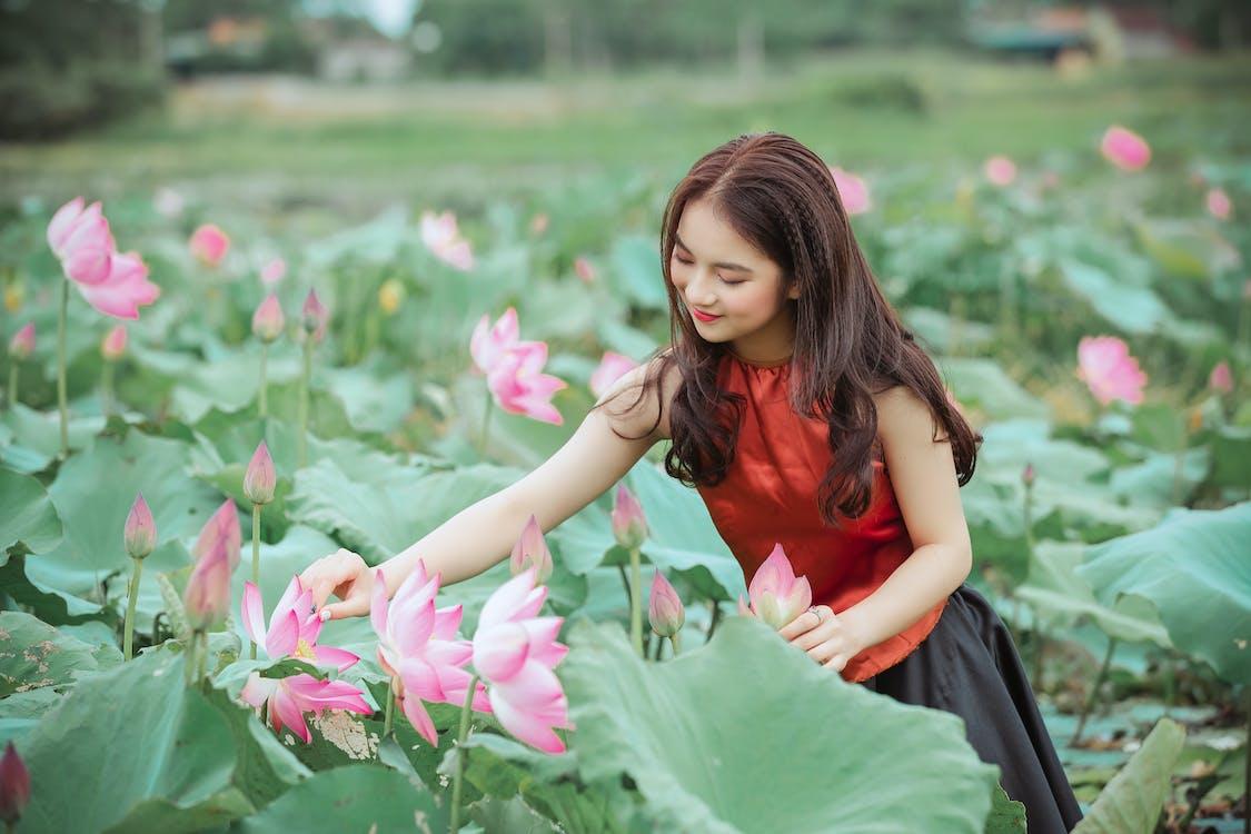 1125x750 Woman In Red Top Holding Pink Lotus Flower · Free
