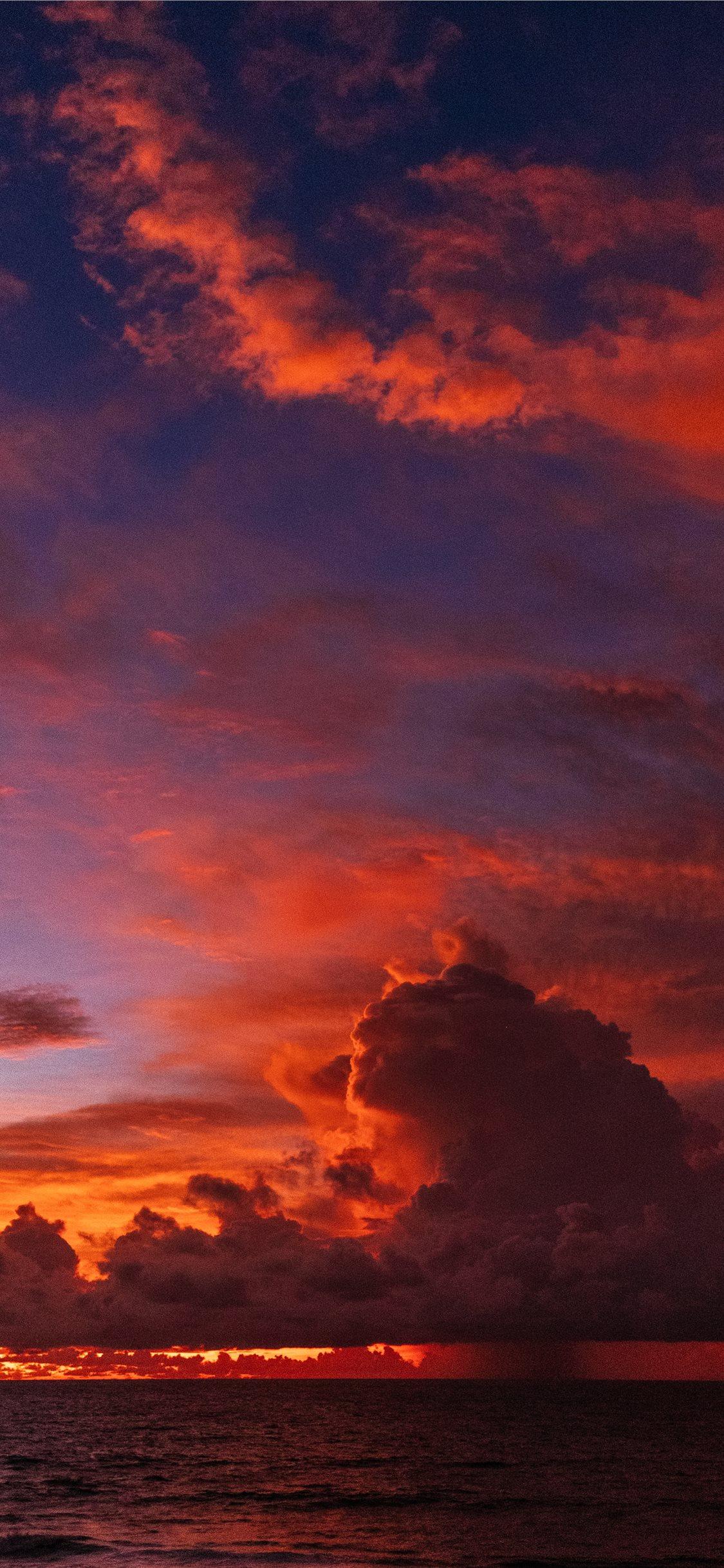 1125x2436 ocean under orange colored clouds iPhone 11 Wallpaper Free Download