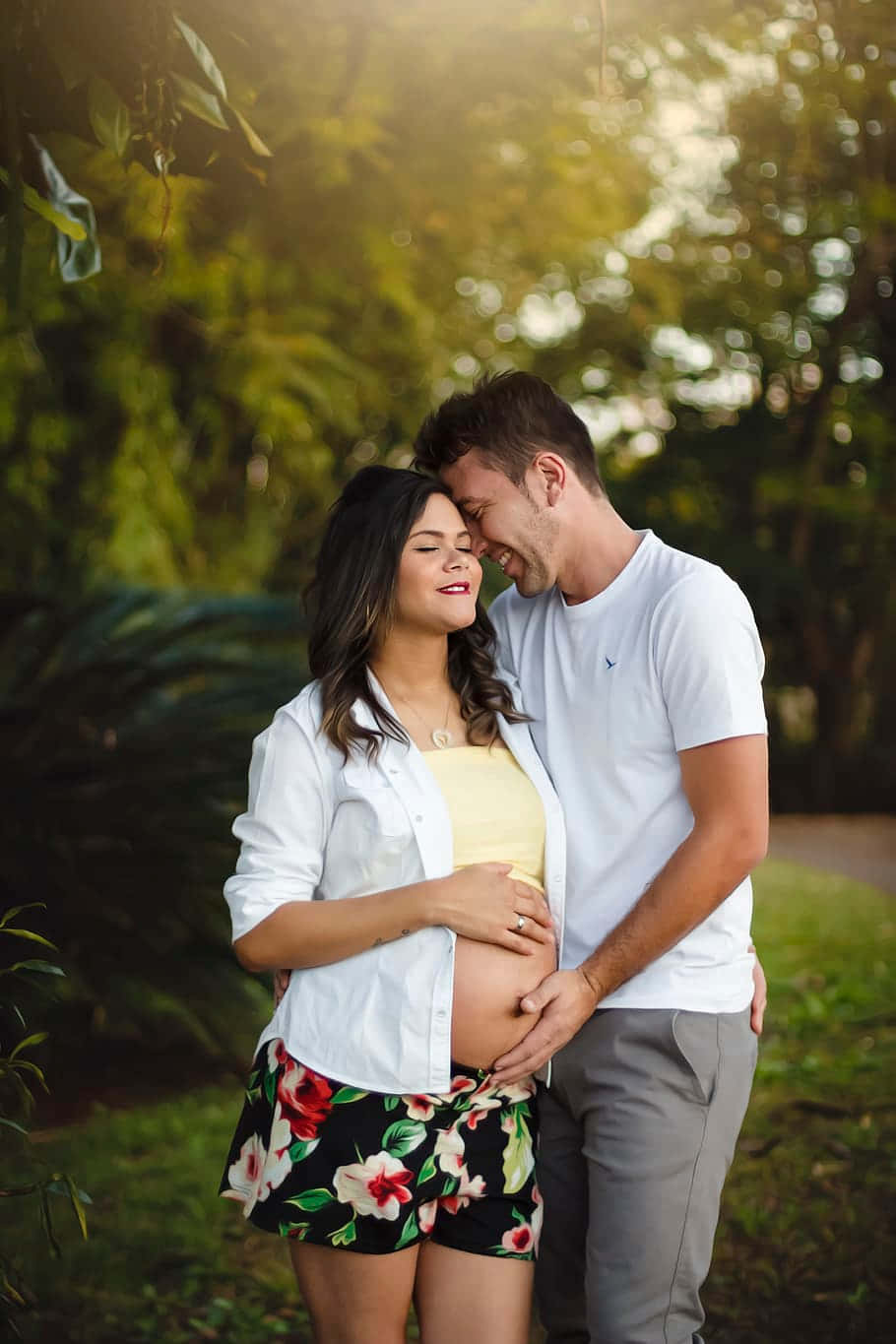 910x1365 Download Smiling Pregnant Couple Touching Baby Bump Wallpaper