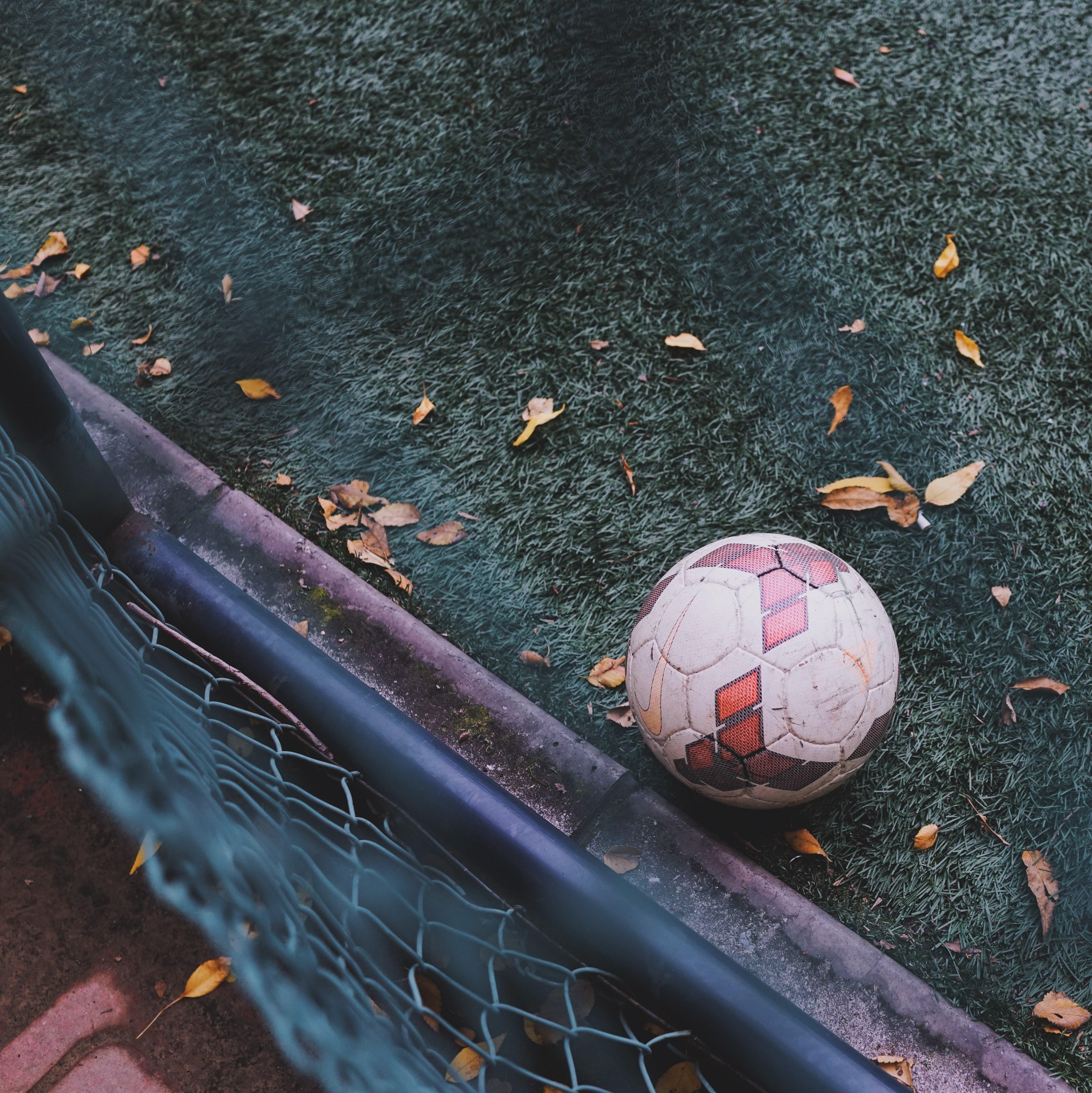 3840x3842 Wallpaper / view over the fence on the soccer ball sitting on a green turf pitch, football on fall ground 4k wallpaper free download