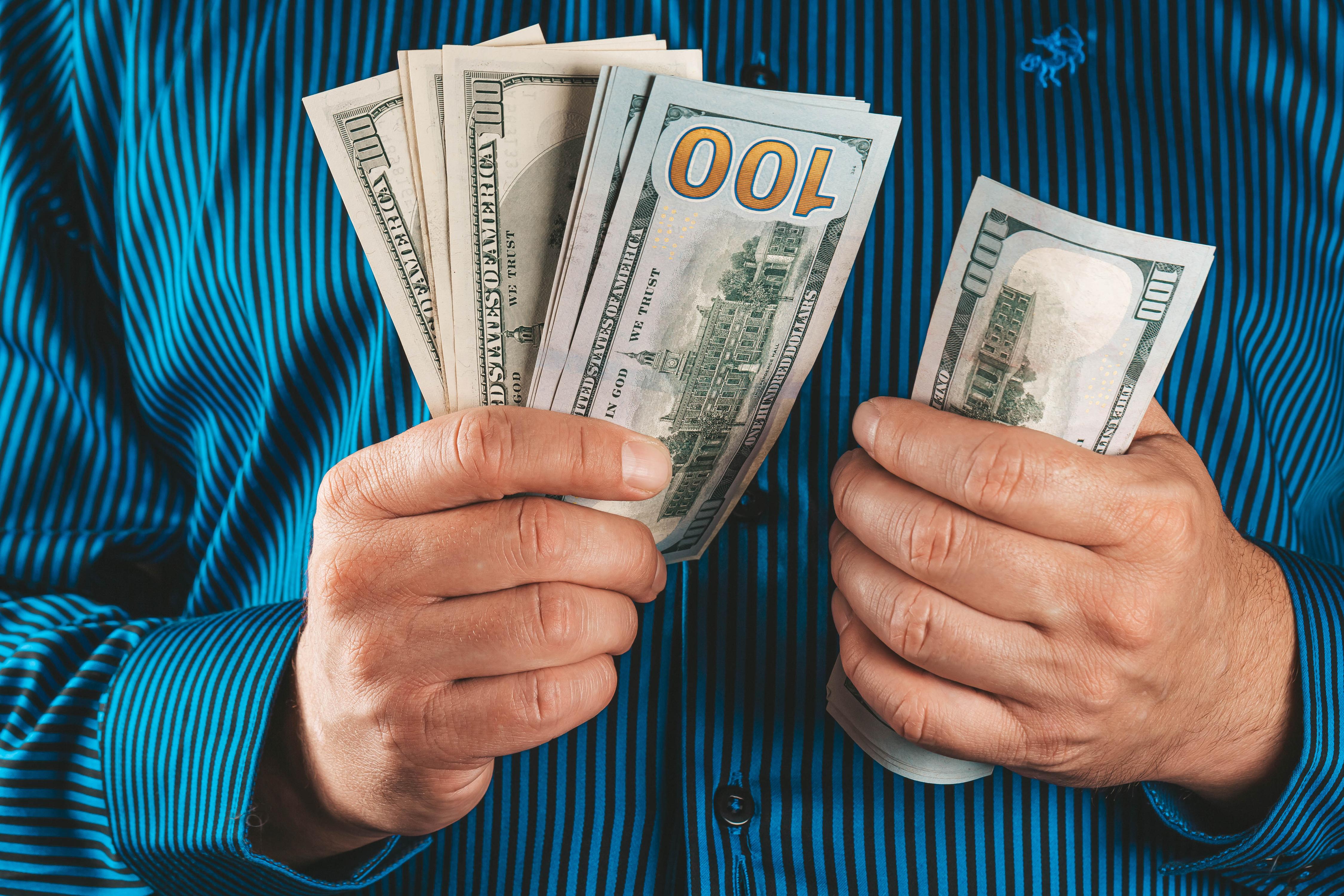 4500x3000 Man counts one hundred dollar bills Desktop wallpaper 1280x800