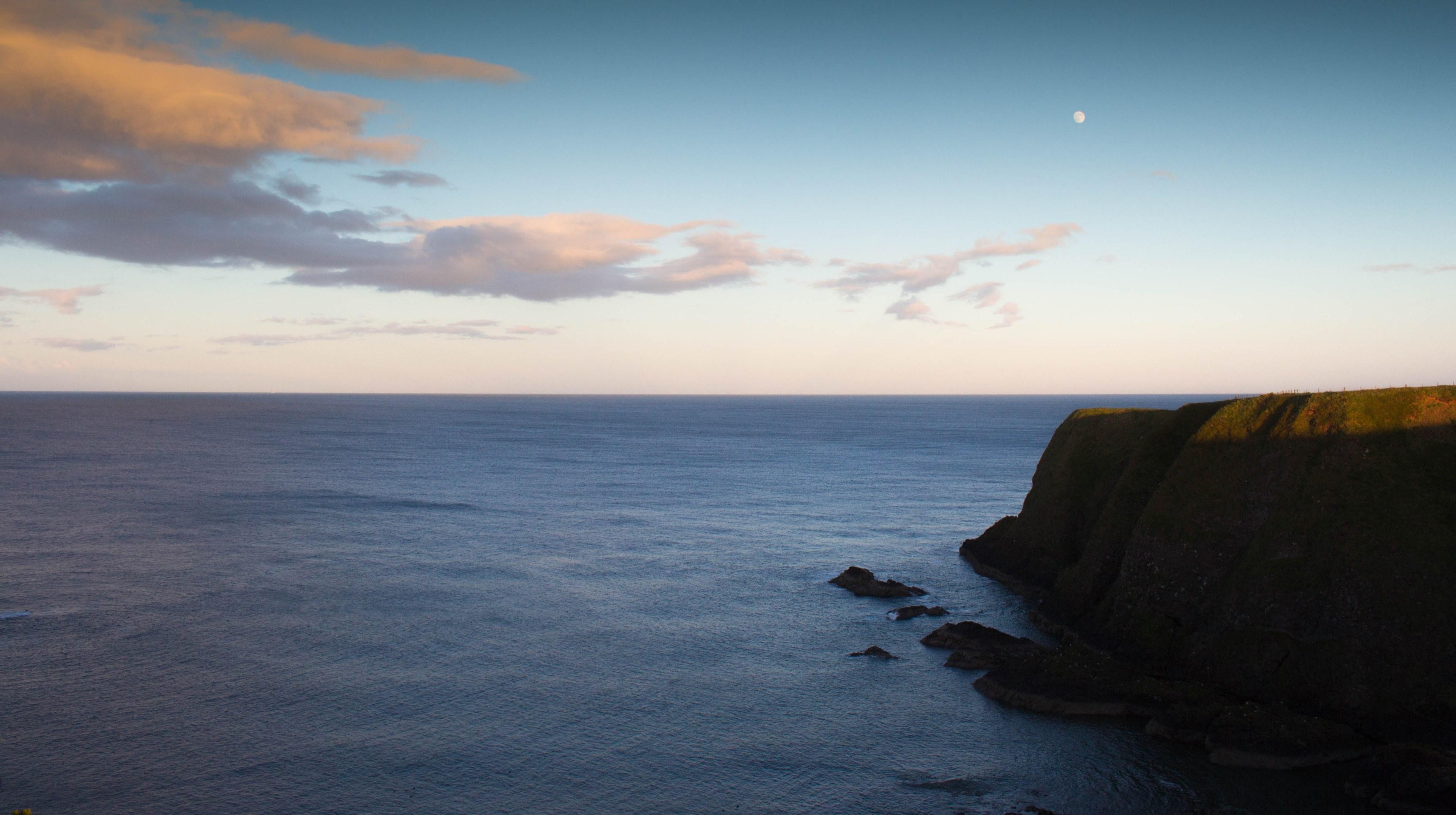 3840x2150 Wallpaper / green cliff above the calm sea with clouds and the moon in the background, green cliff calm sea 4k wallpaper free download