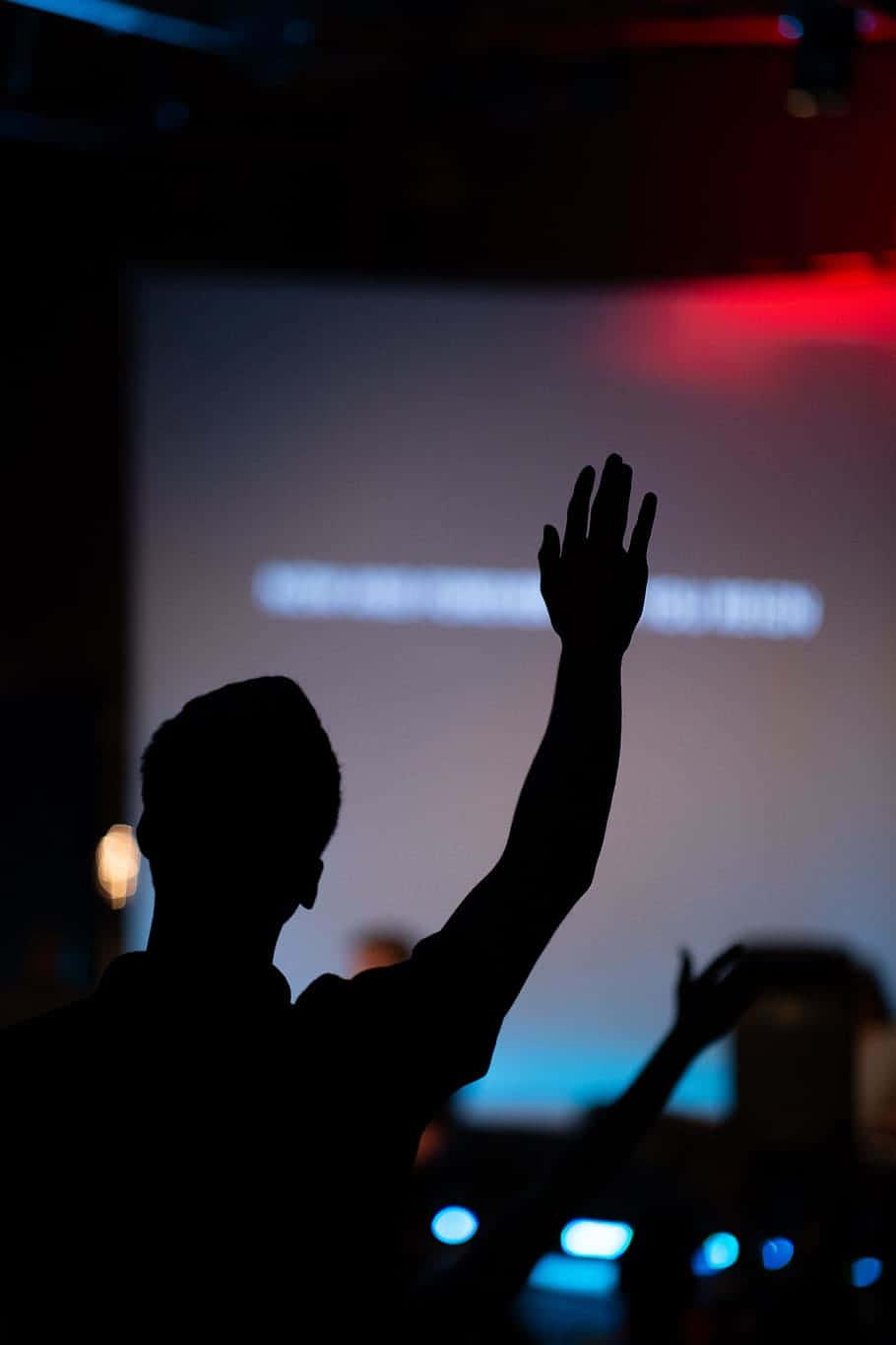 910x1365 Download Silhouette Of A Person Raising Their Hands In Front Of A Screen