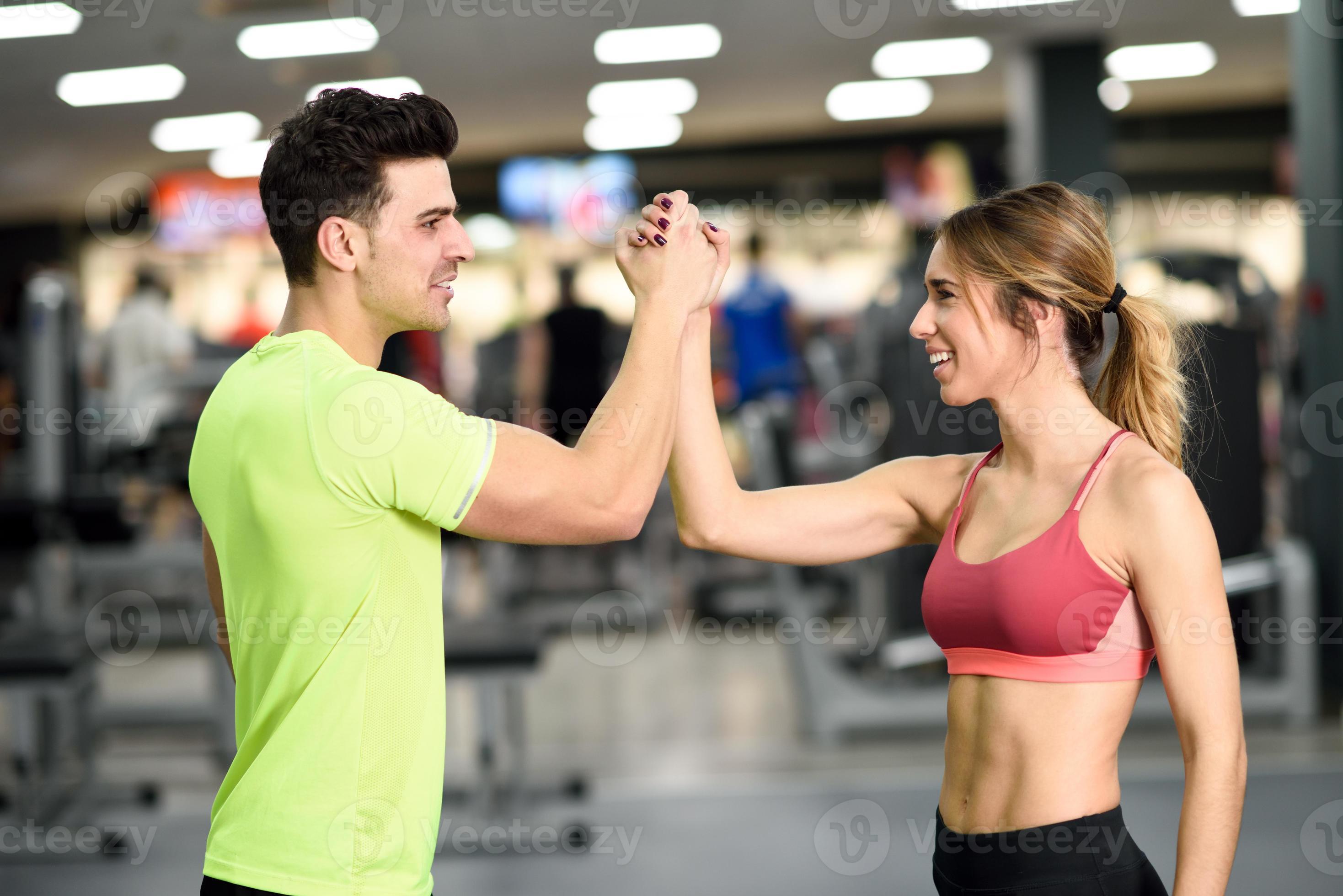 2937x1960 Smiling young man and woman doing high five in gym