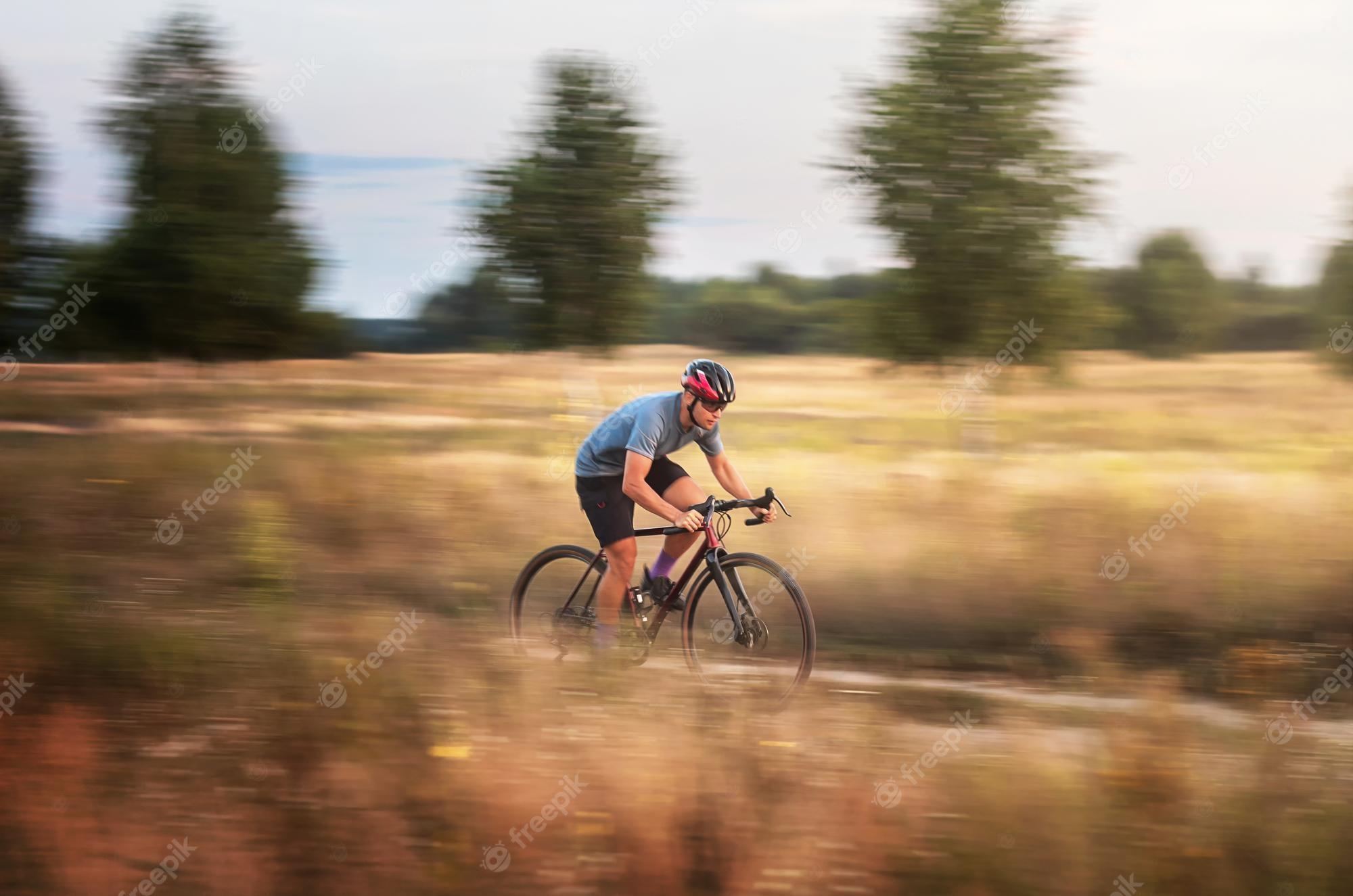 2000x1325 Premium Photo. Cyclist in motion young sporty man rides gravel bike along the trail in the field