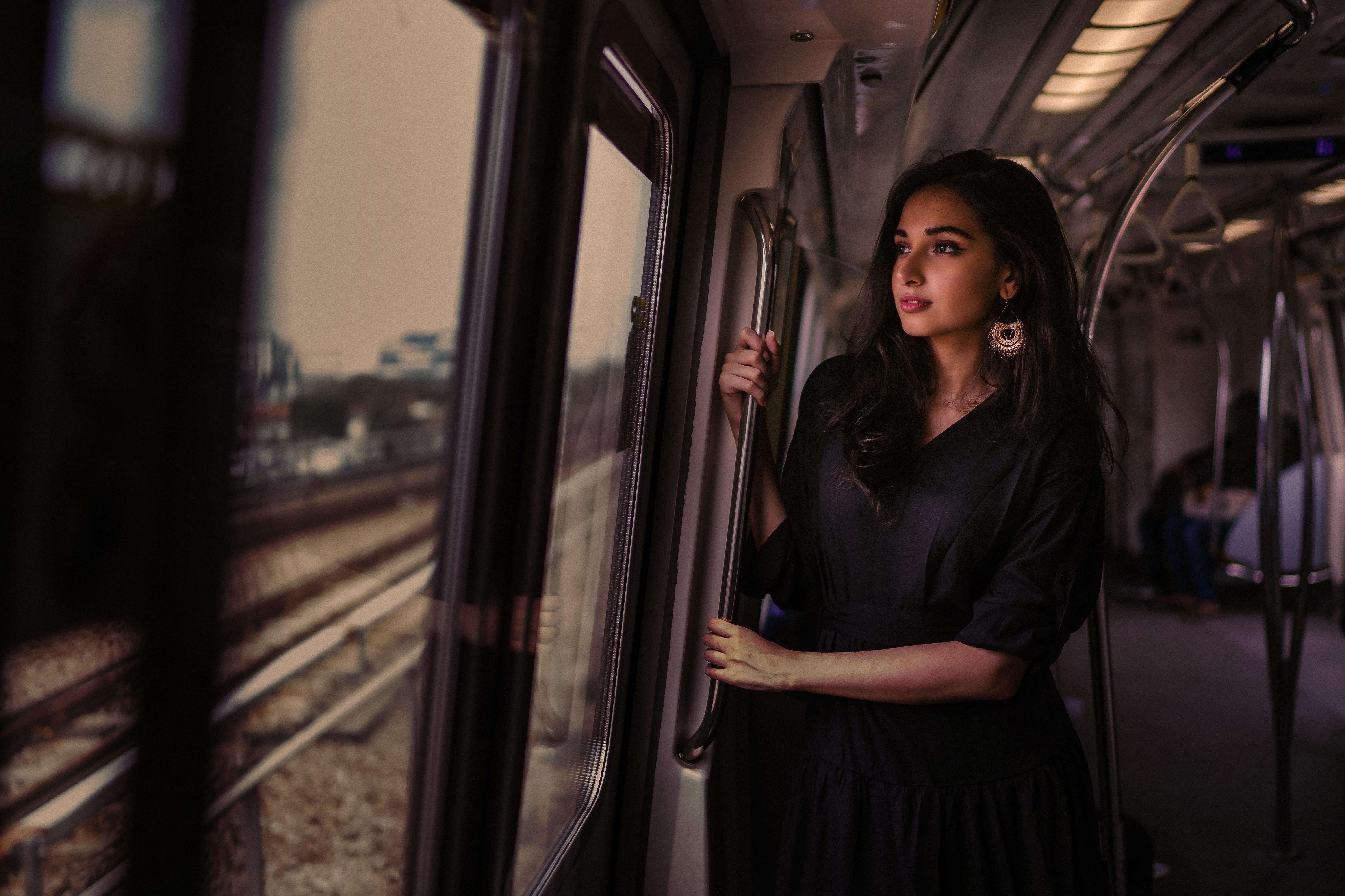 6000x4000 Wallpaper 4k Women Standing In Train Holding Metal Rail While Looking Outside Wallpaper