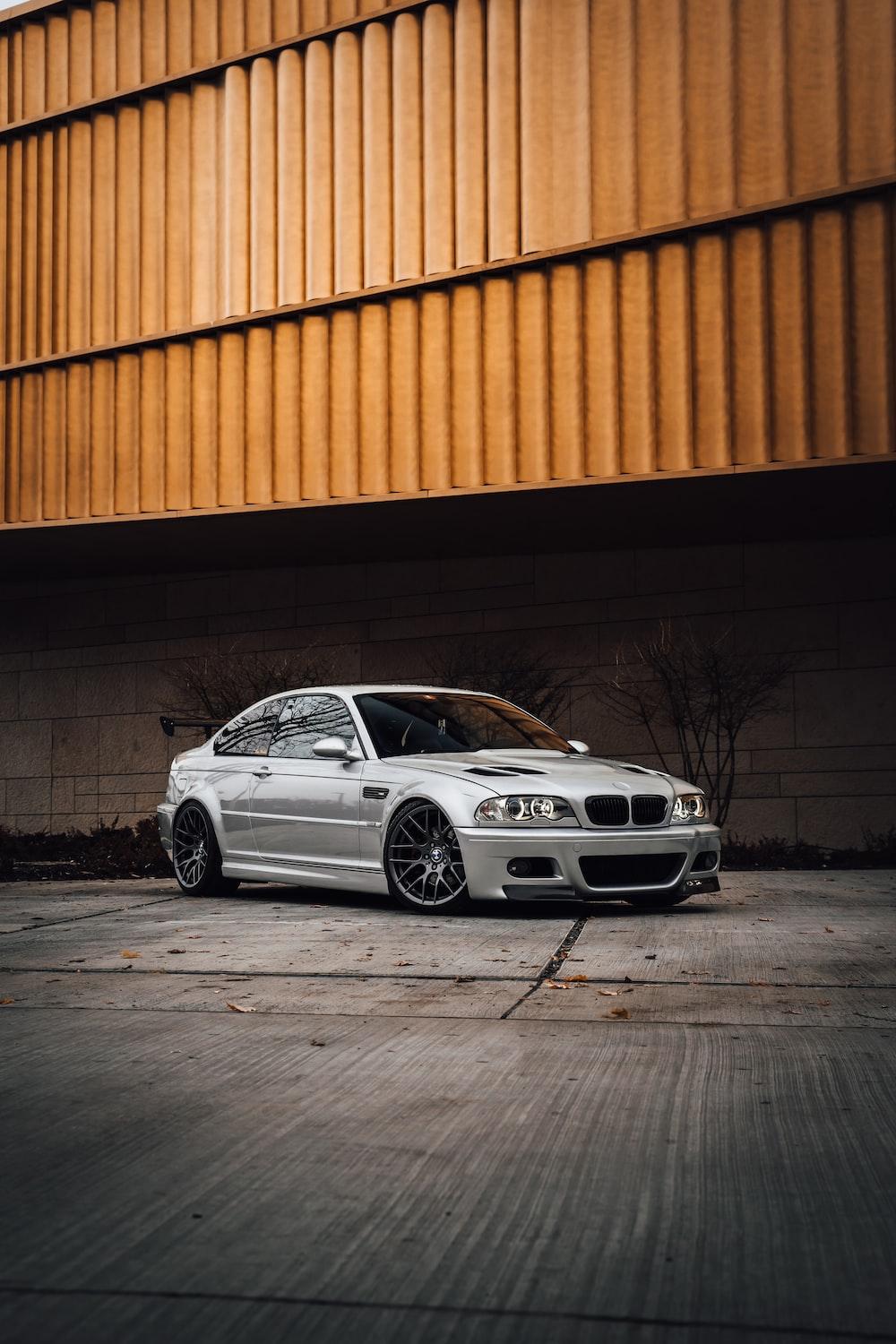1000x1500 White bmw m 3 coupe parked beside orange wall photo