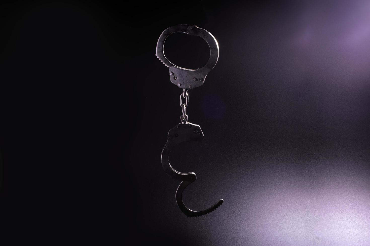 1470x980 silhouette of handcuffs in black background.soft focus