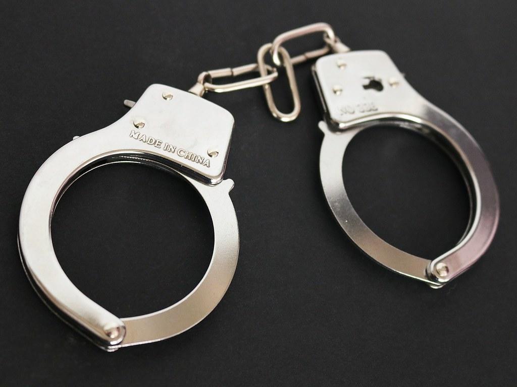 1024x768 Handcuffs with black background. Handcuffs with a black bac