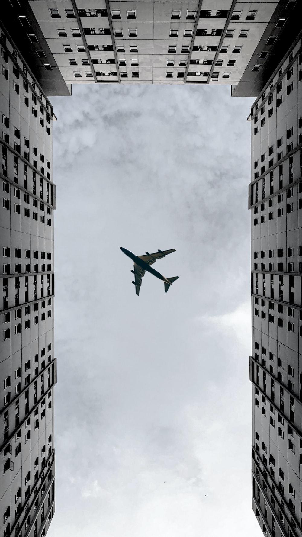 1000x1778 Airplane flying over the building during daytime photo