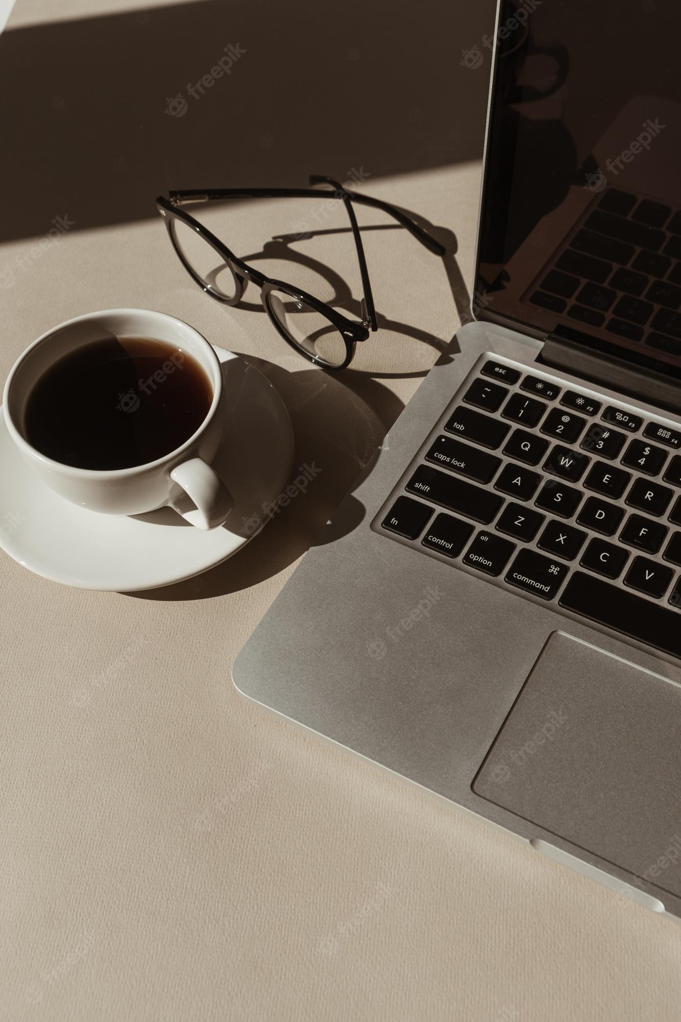 1333x2000 Premium Photo. Home office workspace with laptop computer coffee cup glasses with sunlight shadows aesthetic luxury bohemian minimal lady boss business lifestyle concept