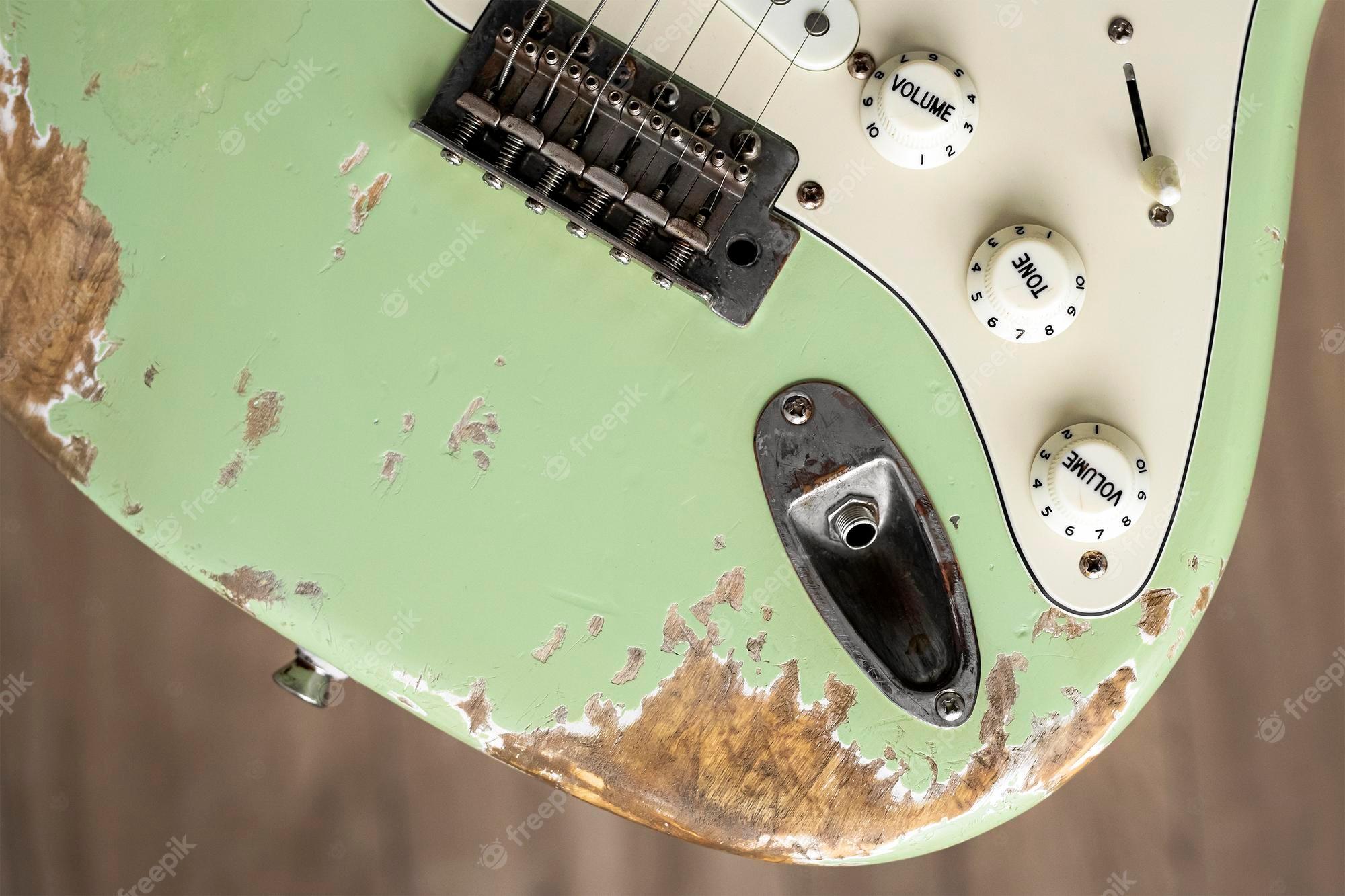 2000x1333 Premium Photo. Old green electric guitar. music wallpaper. grunge background