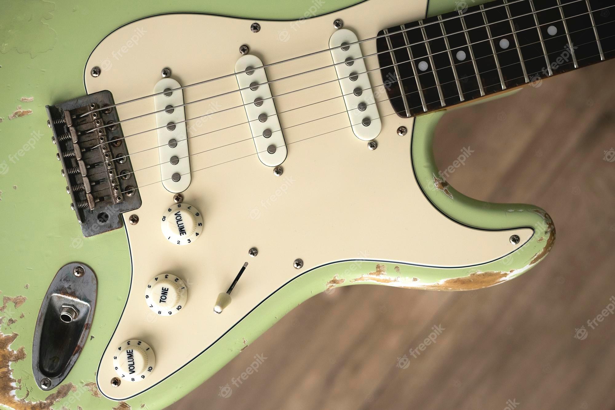 2000x1333 Premium Photo. Old green electric guitar. music wallpaper. grunge background