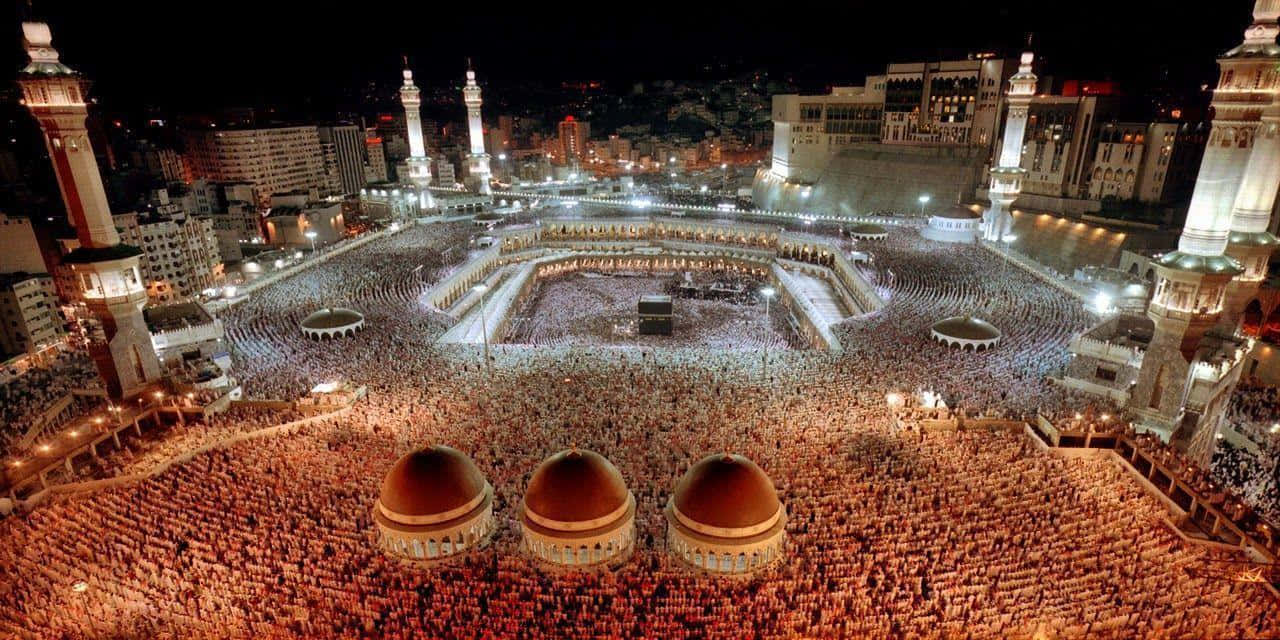 1280x640 Download The Kaaba At Night With Many People Around It