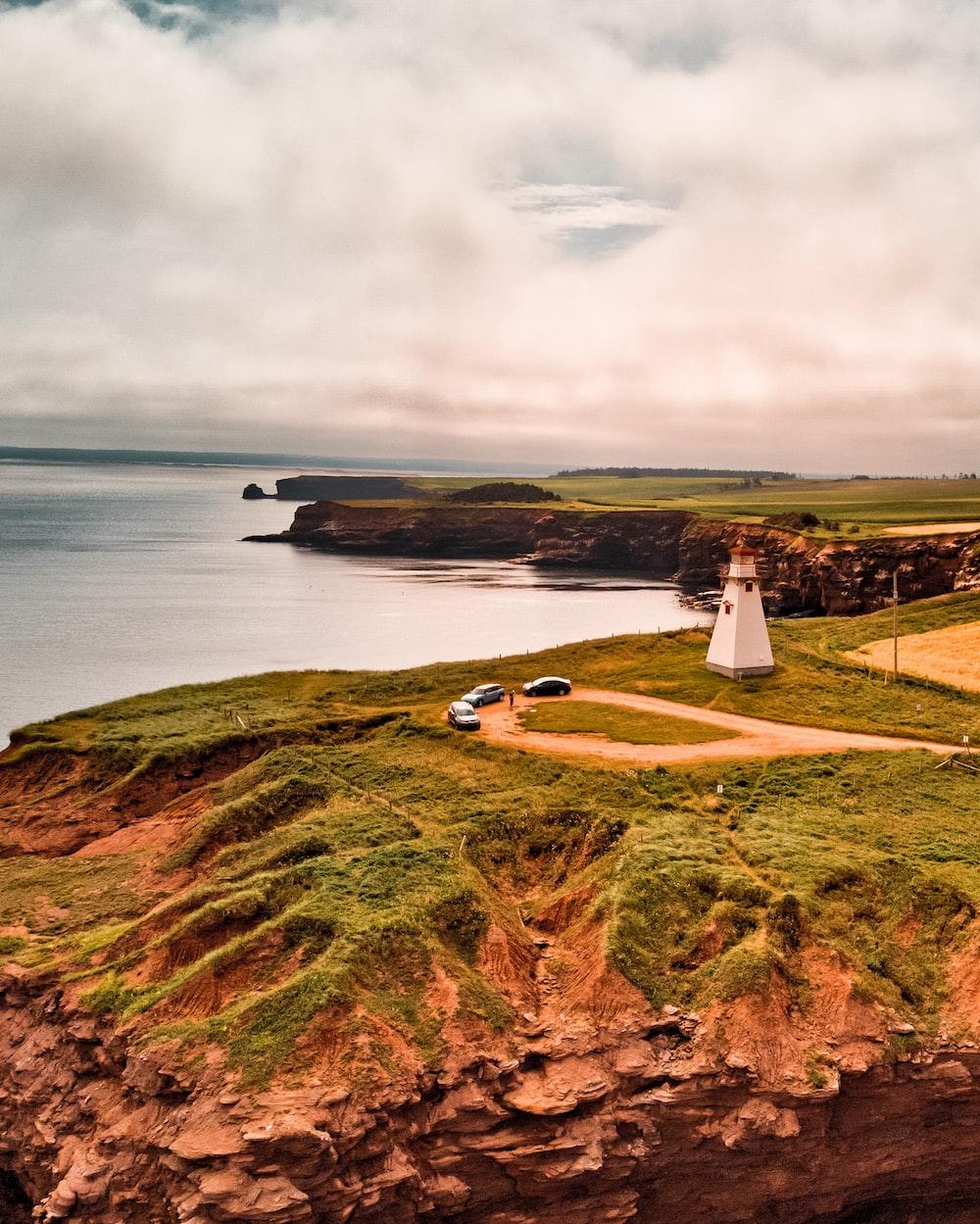1000x1249 A lighthouse sitting on top of a lush green hillside photo