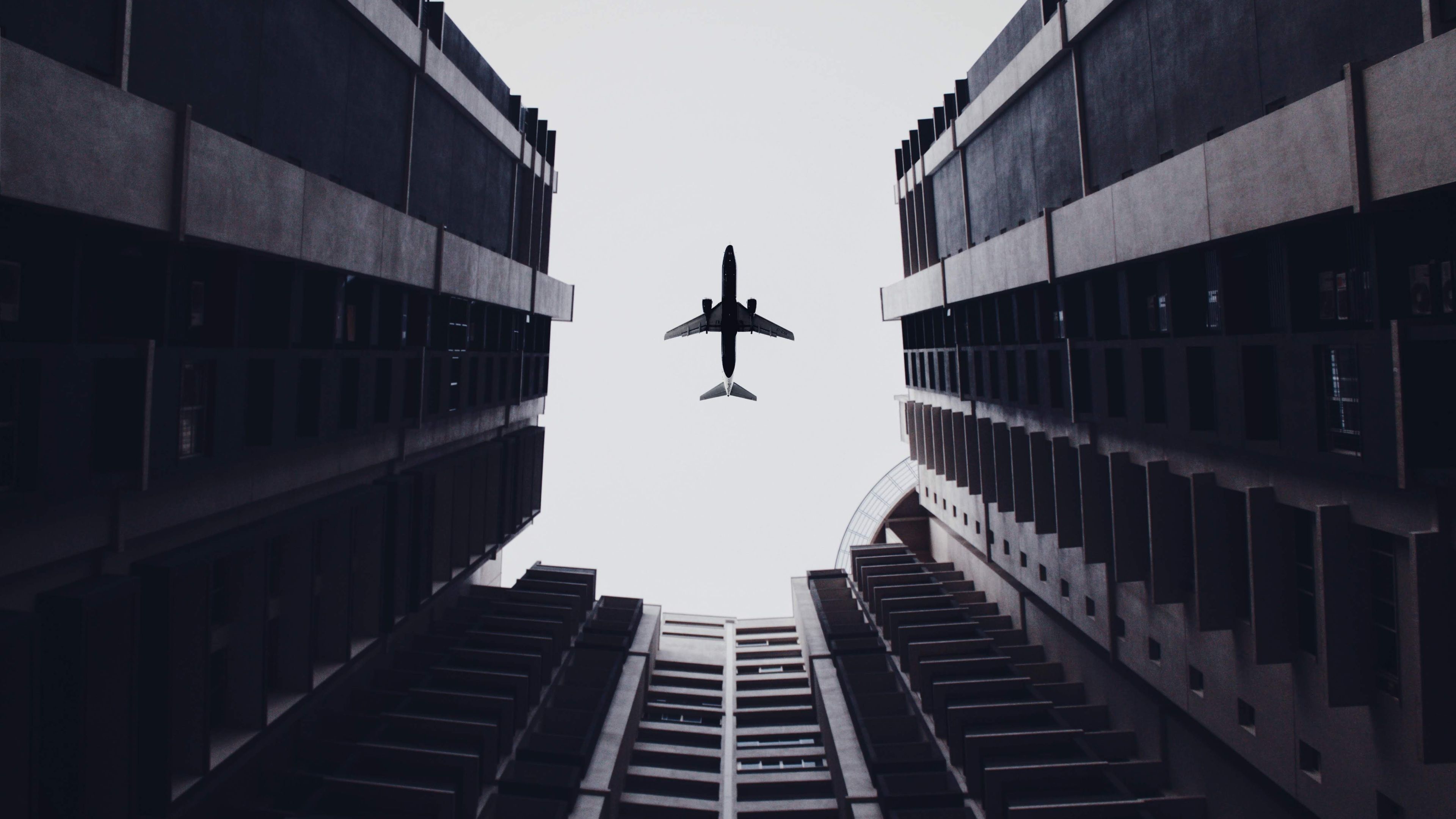 3840x2160 Wallpaper 4k Airplane Flying Above The Buildings Wallpaper