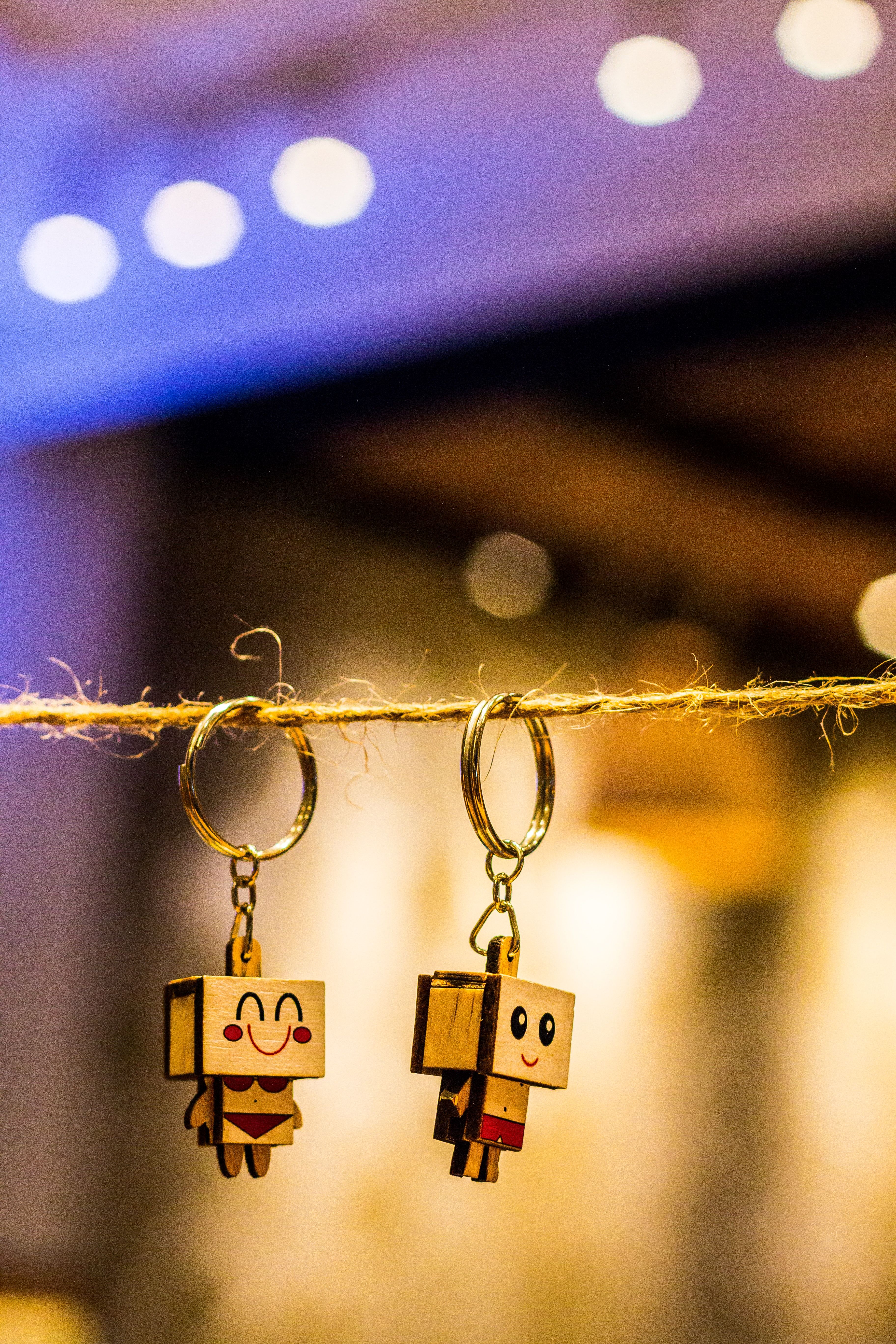3648x5472 Two Brown Wooden Character Keychains Hanged on Brown Rope · Free