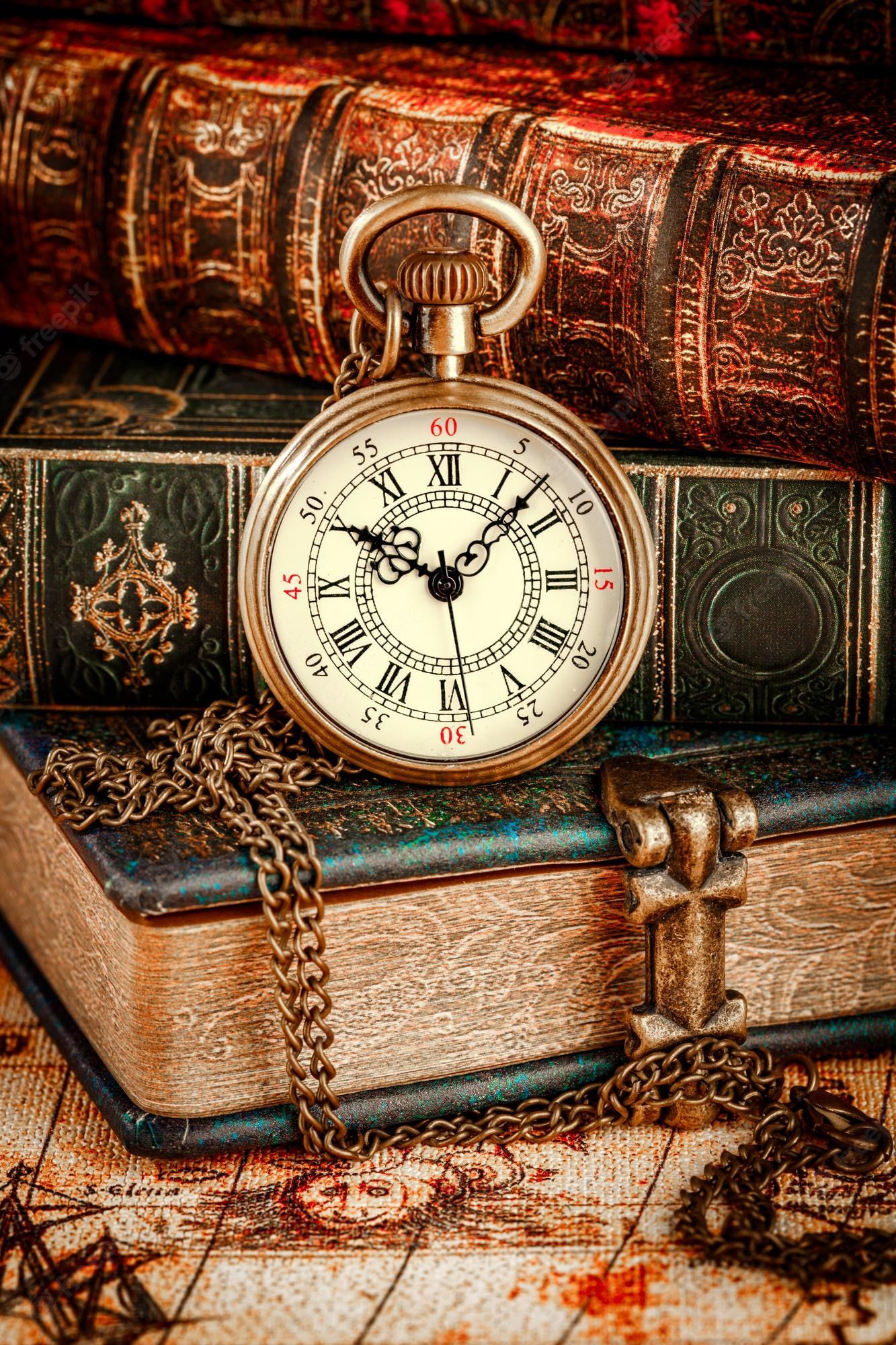 1333x2000 Premium Photo. Vintage antique pocket watch on the background of old books