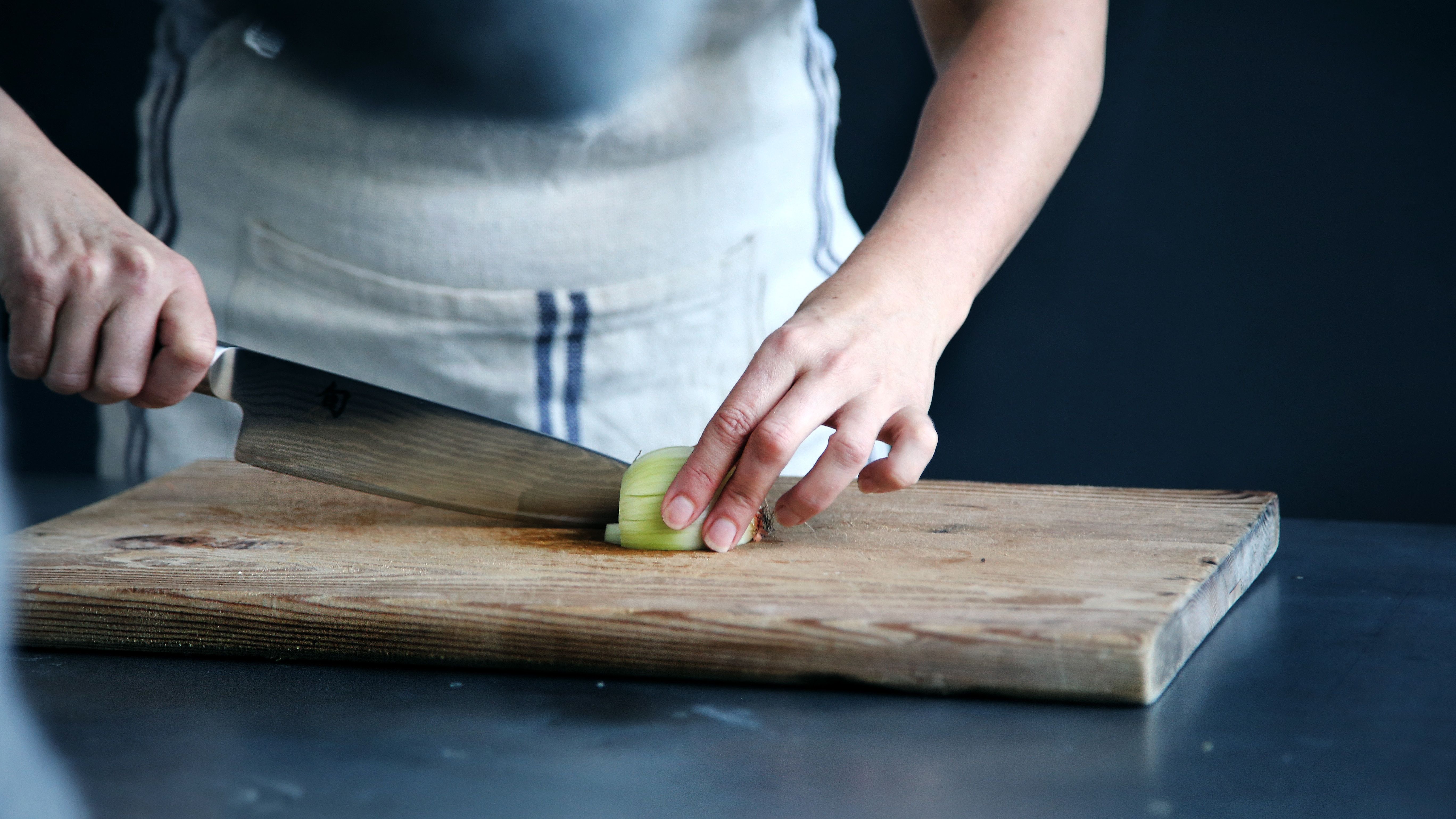 5472x3078 5472x3078 food prep, apron, food preparation, hand, kitchen, Free image, food, cut, prep, cook, chef, cutting board, onion, chopping board, board, cooking utensil, vegetable, cutting, knife, holding, cooking