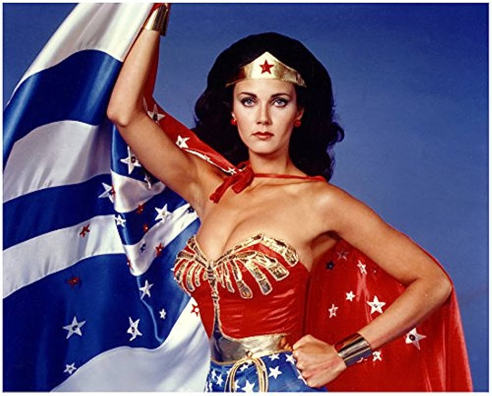 1000x804 Lynda Carter 8 Inch X 10 Inch PHOTOGRAPH Wonder Woman TV Series (1975 1979) Holding Cape Up W Right Hand Blue Background Kn At Amazon's Entertainment Collectibles Store