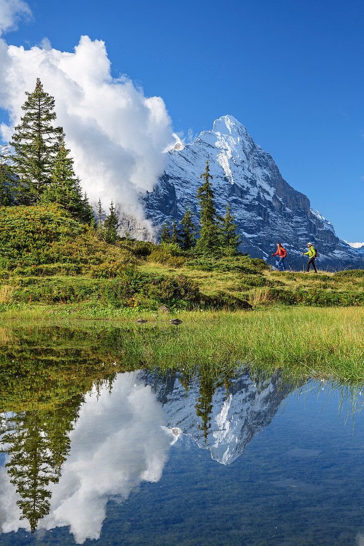 733x1100 Man and woman hiking on mountain lake