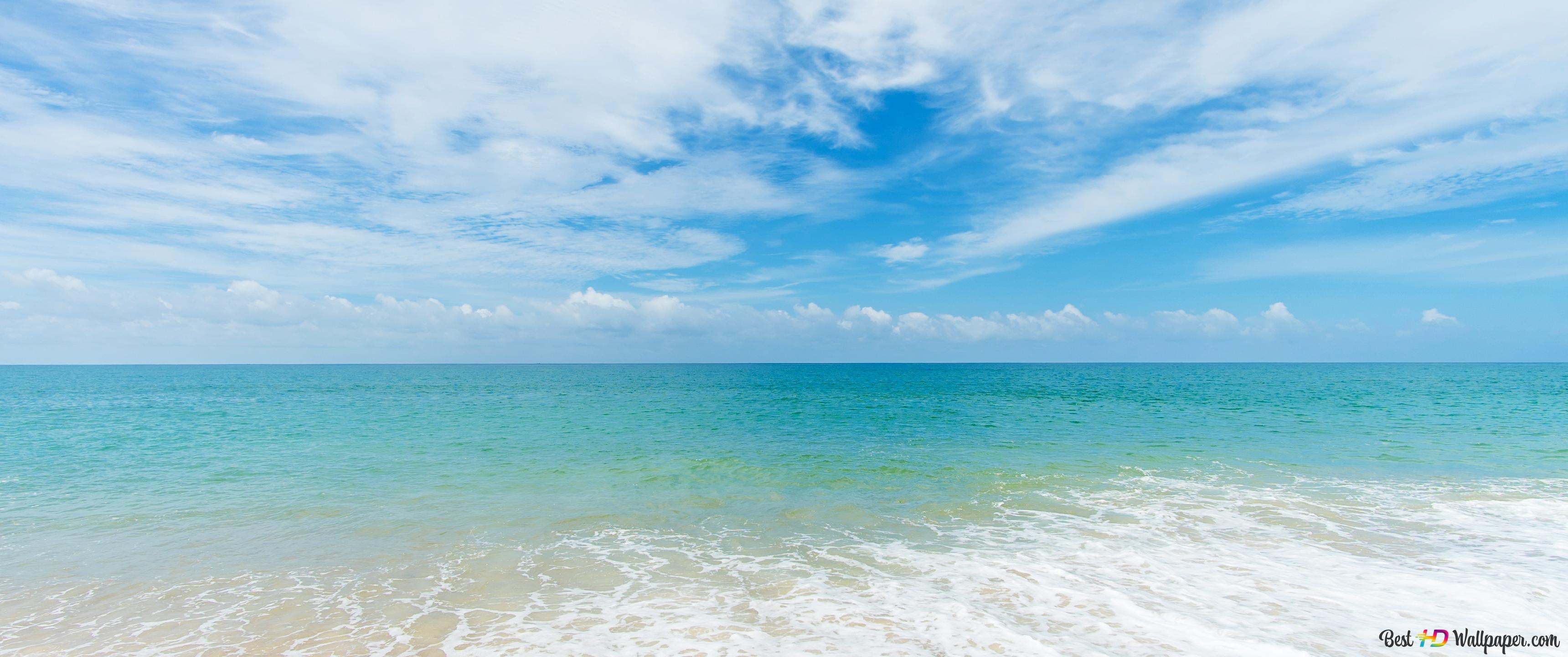 3440x1440 Ocean waves hitting the beach in clear cloudy weather 4K wallpaper download