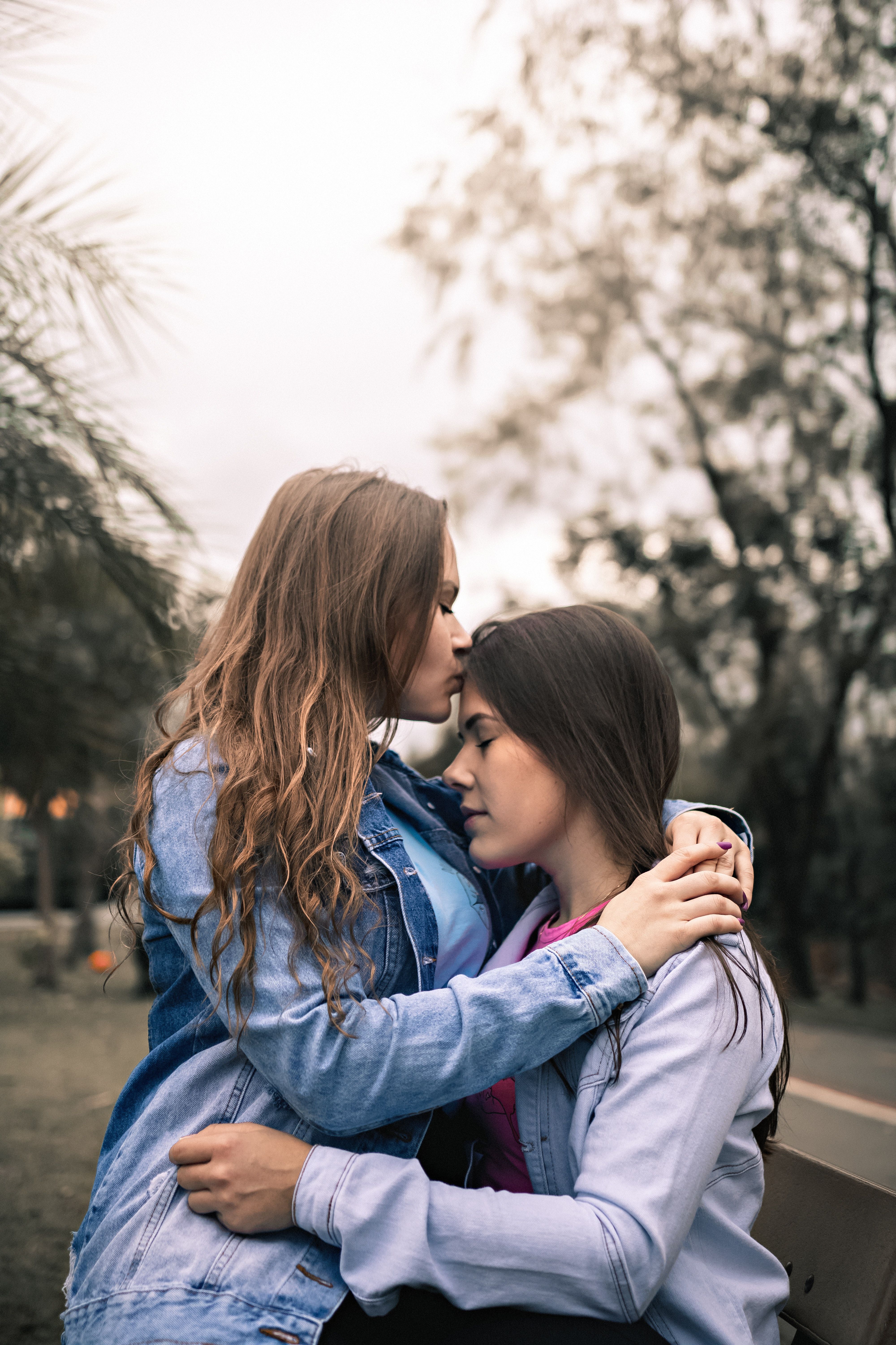4000x6000 Happy young lesbian couple embracing on bench in park · Free