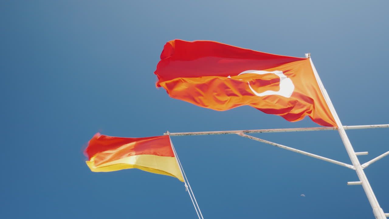 1280x720 Premium stock video with crescent turkey flag and rescue service flag against the blue sky beach season in turkey